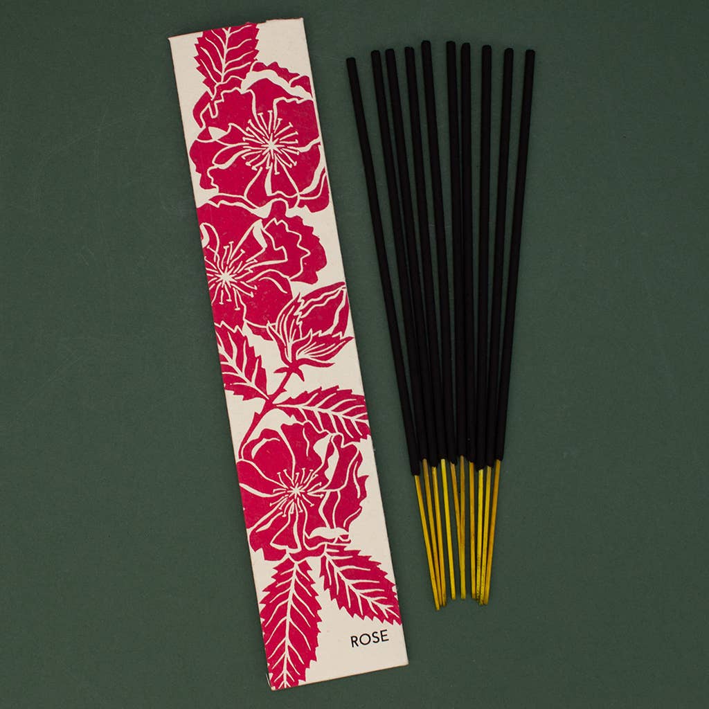 Rose incense sticks with a floral packaging label on a green background