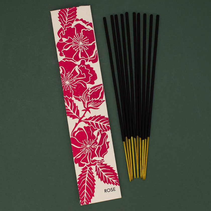 Rose incense sticks with a floral packaging label on a green background