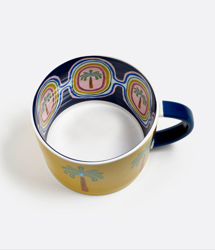 Ceramic mug with palm tree design on a white background