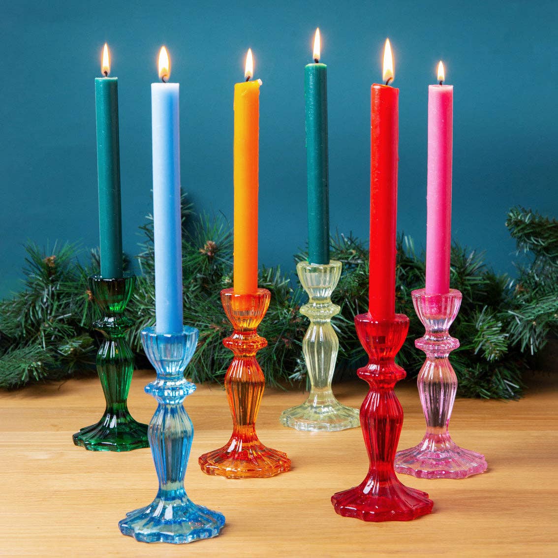 Colorful candles in glass candlesticks with a blue background