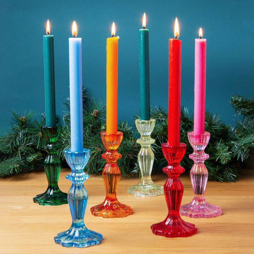 Colorful candles in glass candlesticks with a blue background