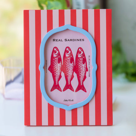 Card with red striped border and illustration of sardines on a pink background