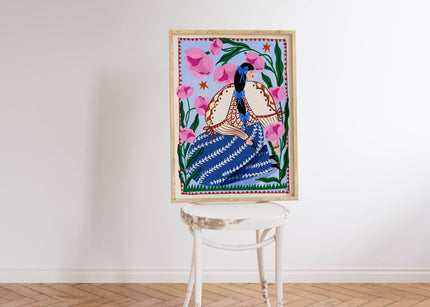 Framed artwork of a woman and flowers on a white wall