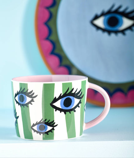 Mug with eye design on a colorful plate background