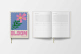 Open planner with floral design and 'BLOOM' text on a white background