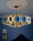 Ceiling lightshade with colourful design against a blue wall
