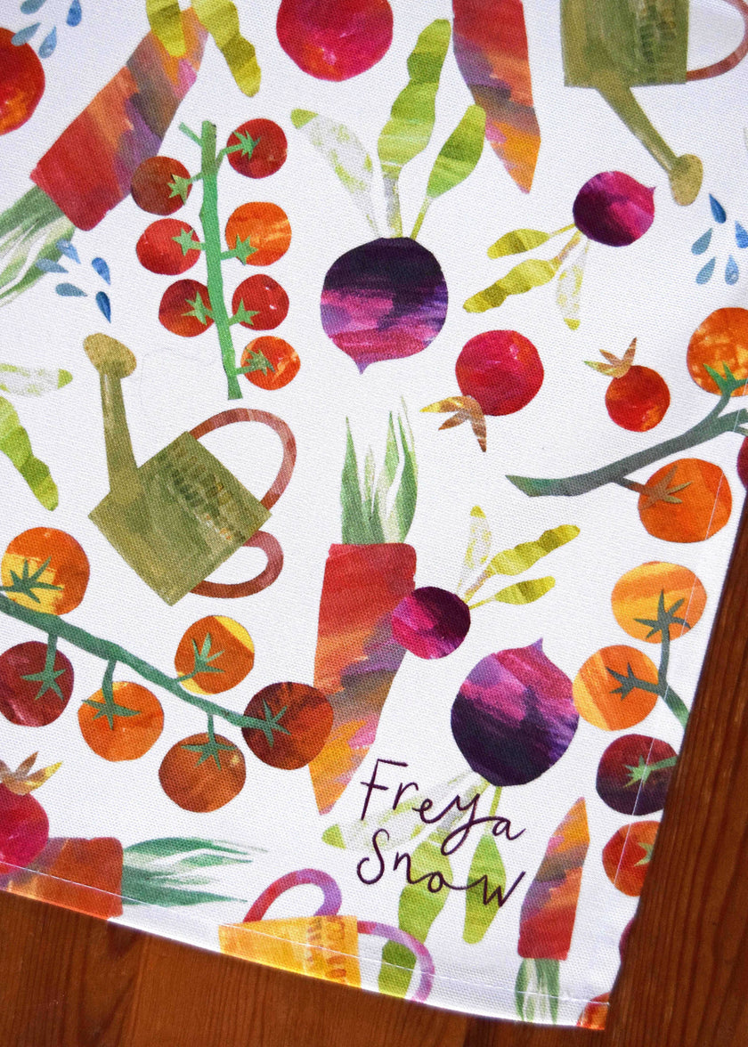 Colorful pattern of vegetables and a watering can on a white background with 'Freya Snow' branding.