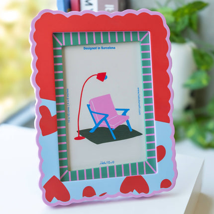Colorful photo frame with a heart design on a white surface.