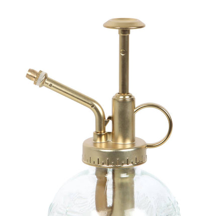 Brass and glass plant mister on a white background