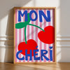 Framed artwork with 'MON CHERI' text and cherries on a striped background