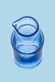 Blue glass pitcher on a blue background