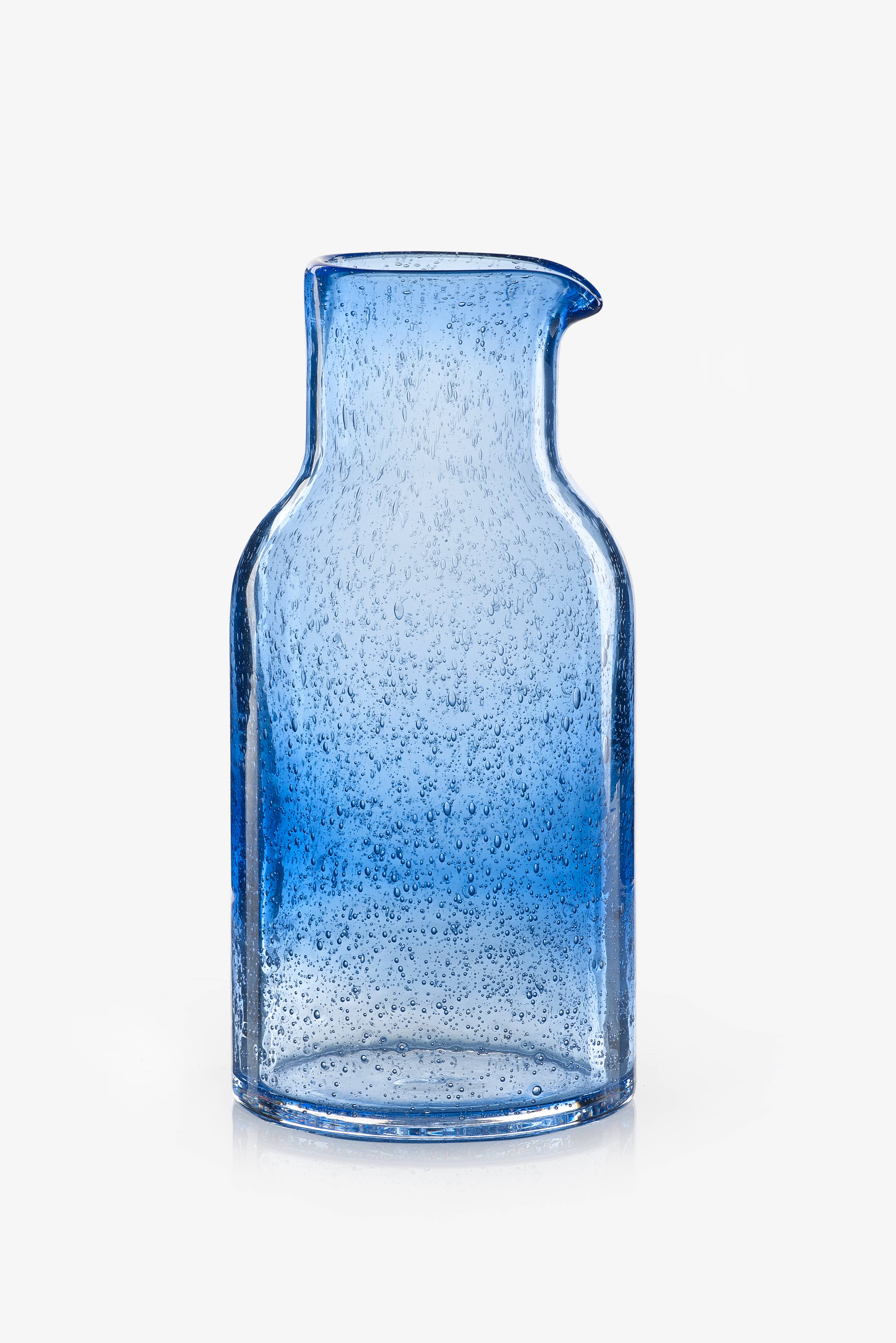 Blue glass carafe with a textured surface on a white background