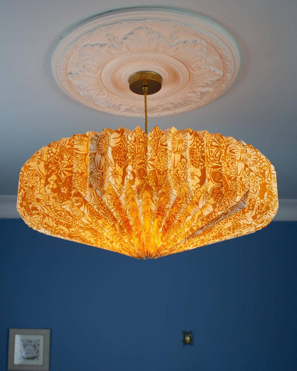 Decorative yellow spring bloom ceiling light shade against a blue wall.