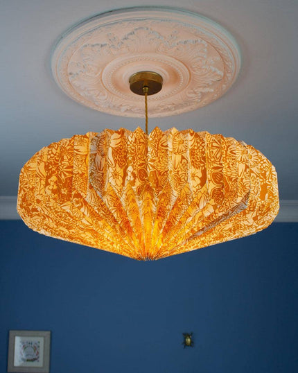 Decorative yellow spring bloom ceiling light shade against a blue wall.