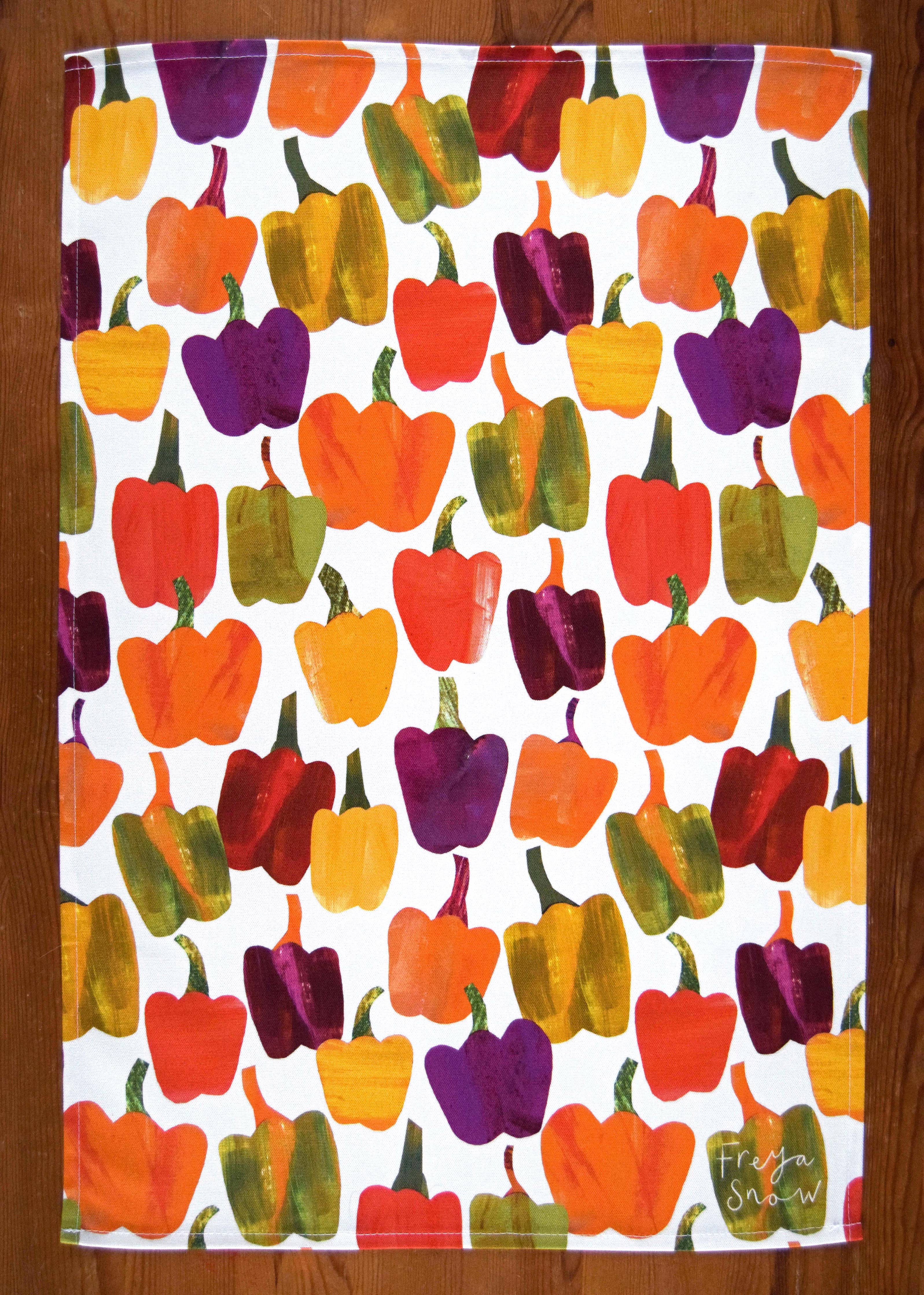 Towel with colorful bell pepper pattern on a wooden surface
