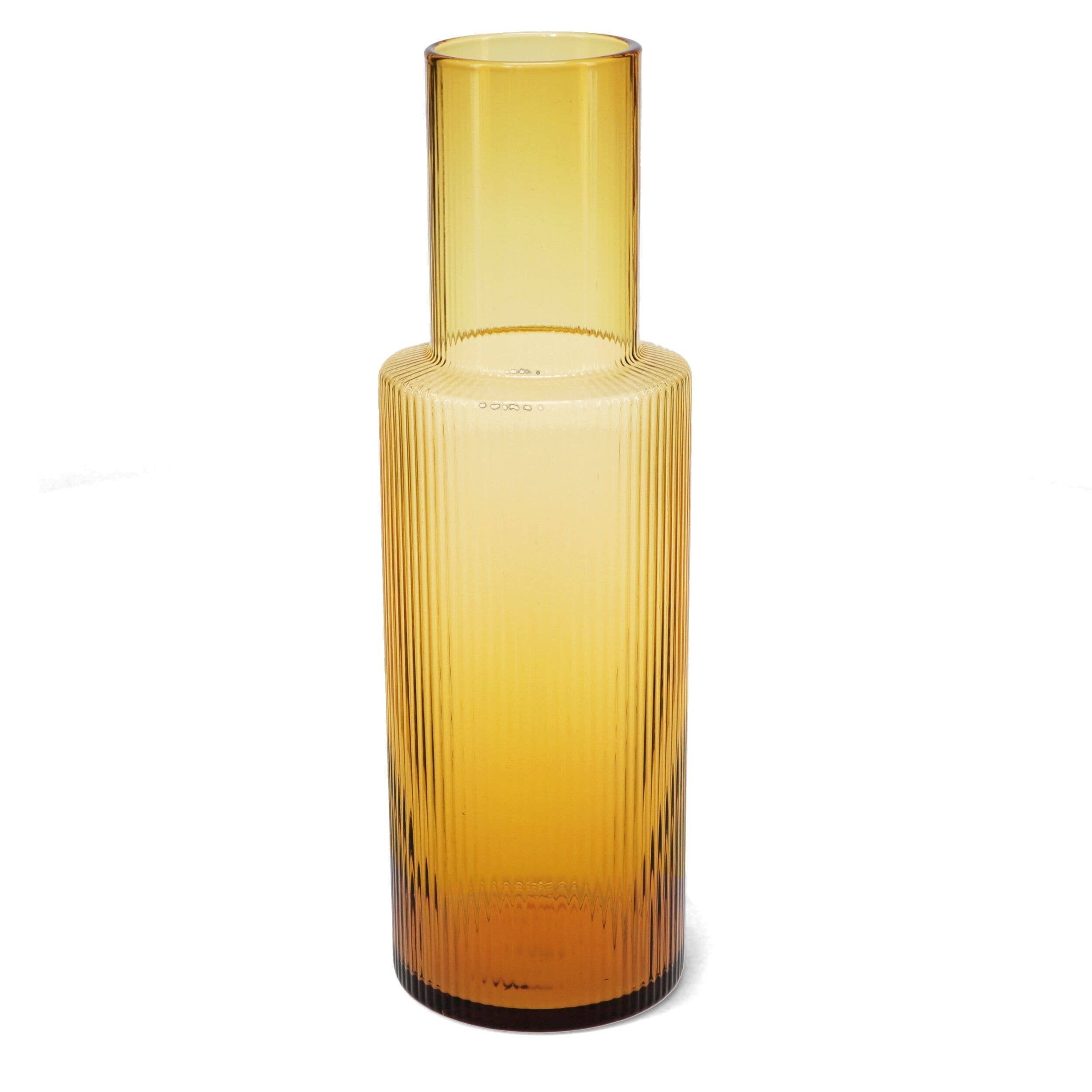 Amber glass carafe with textured design on a white background