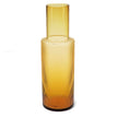 Amber glass carafe with textured design on a white background
