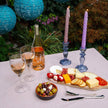 Outdoor setting with a charcuterie board, wine glasses, and candles on a table.