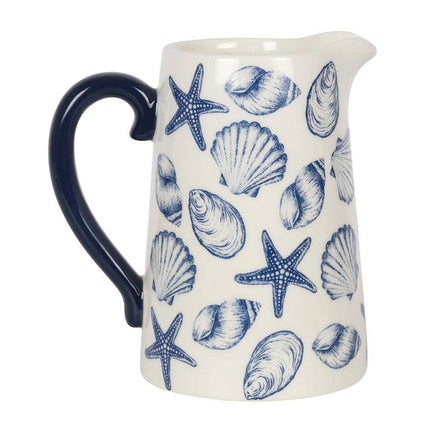 White ceramic pitcher with blue sea shell and starfish pattern on a white background