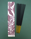 Incense sticks with a sandalwood-scented packaging on a green background