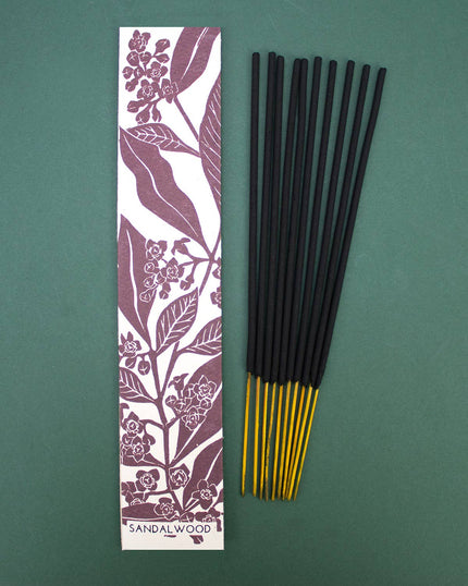 Incense sticks with a sandalwood-scented packaging on a green background
