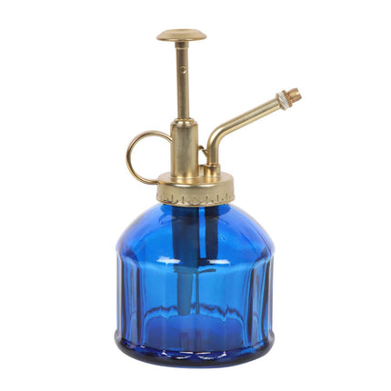Blue glass spray bottle with brass nozzle on a white background
