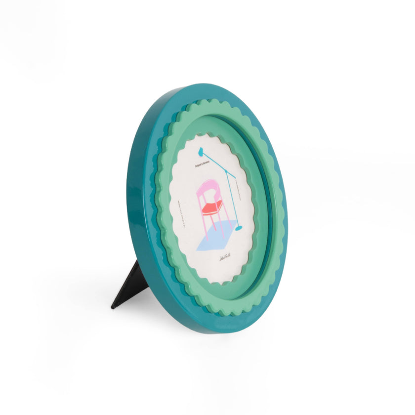 Round green photo frame on a stand against a white background