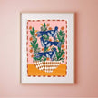 Framed artwork with blue birds and green leaves on a pink wall