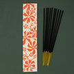 Parijat incense sticks with a floral packaging label on a green background