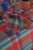 Red and blue plaid fabric napkins with an embroidered apple design on a colourful plaid tablecloth.