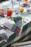 Colourful plaid tablecloth with a matching napkin embroidered with a crab on a dining table.