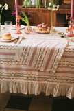 Decorative tablecloth with floral pattern on a table set for a meal.