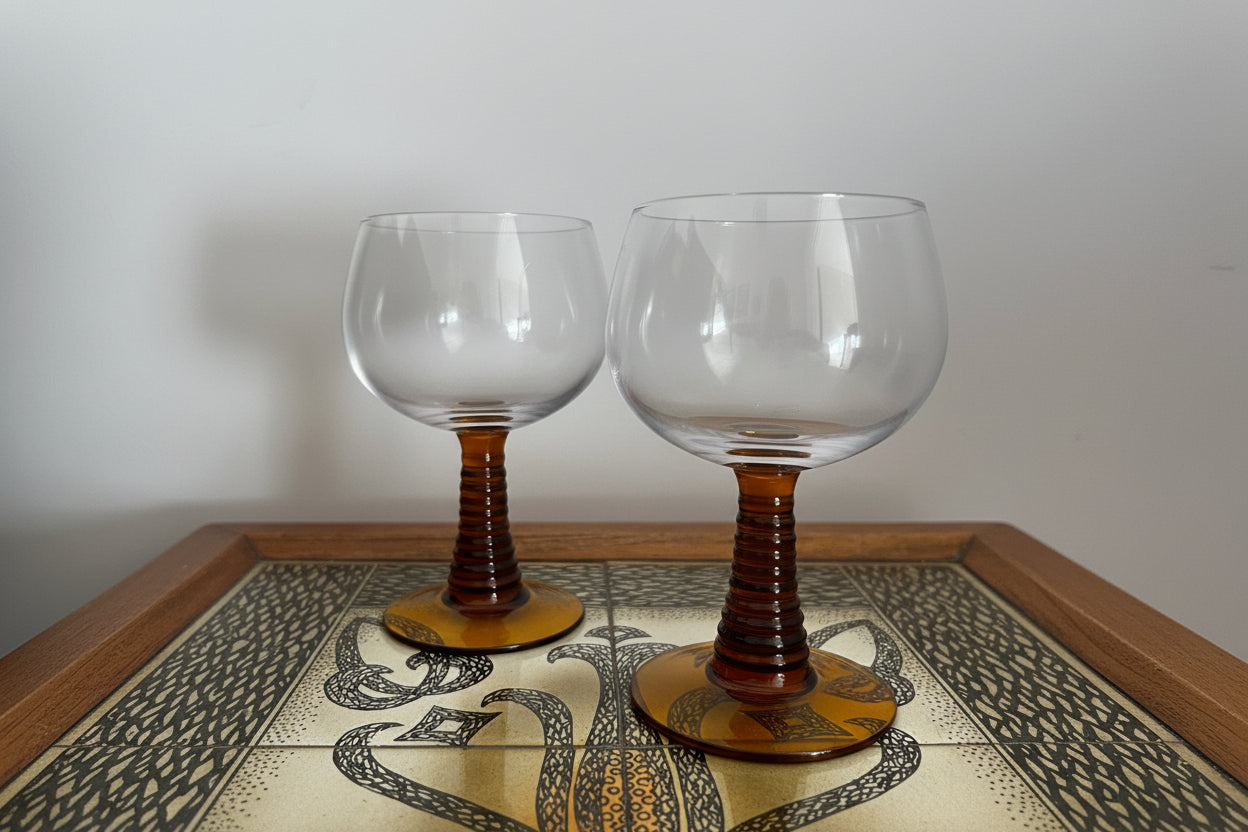 Two amber-roemer glasses on a decorative table