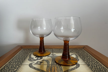 Two amber-roemer glasses on a decorative table