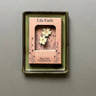 Decorative plant pot companion with floral primrose design in a box labeled 'Lily Faith' on a grey background.