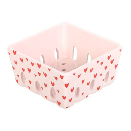 Pink storage basket with red heart pattern on a white background