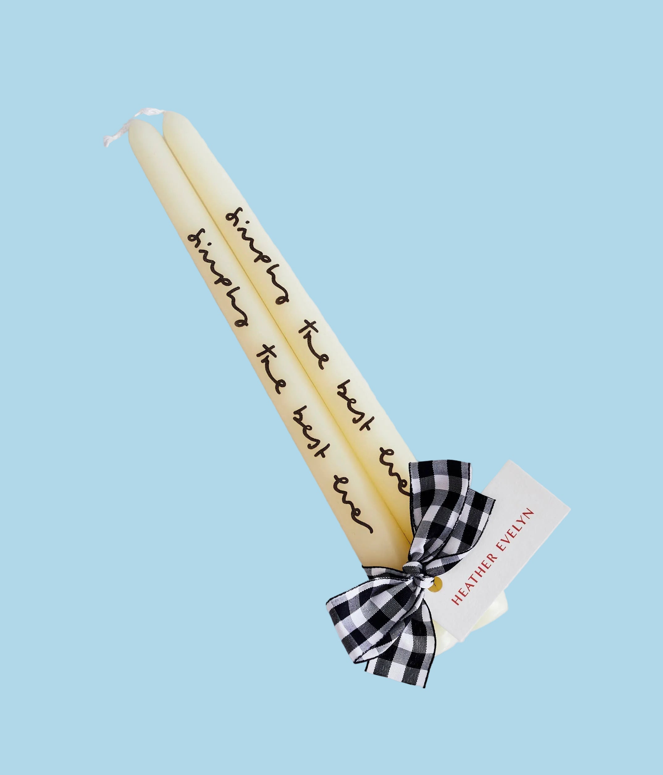 Two white candles with 'simply the best ever' black text and a black and white checkered bow. 