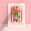 Framed artwork of a floral vase design on a pink background