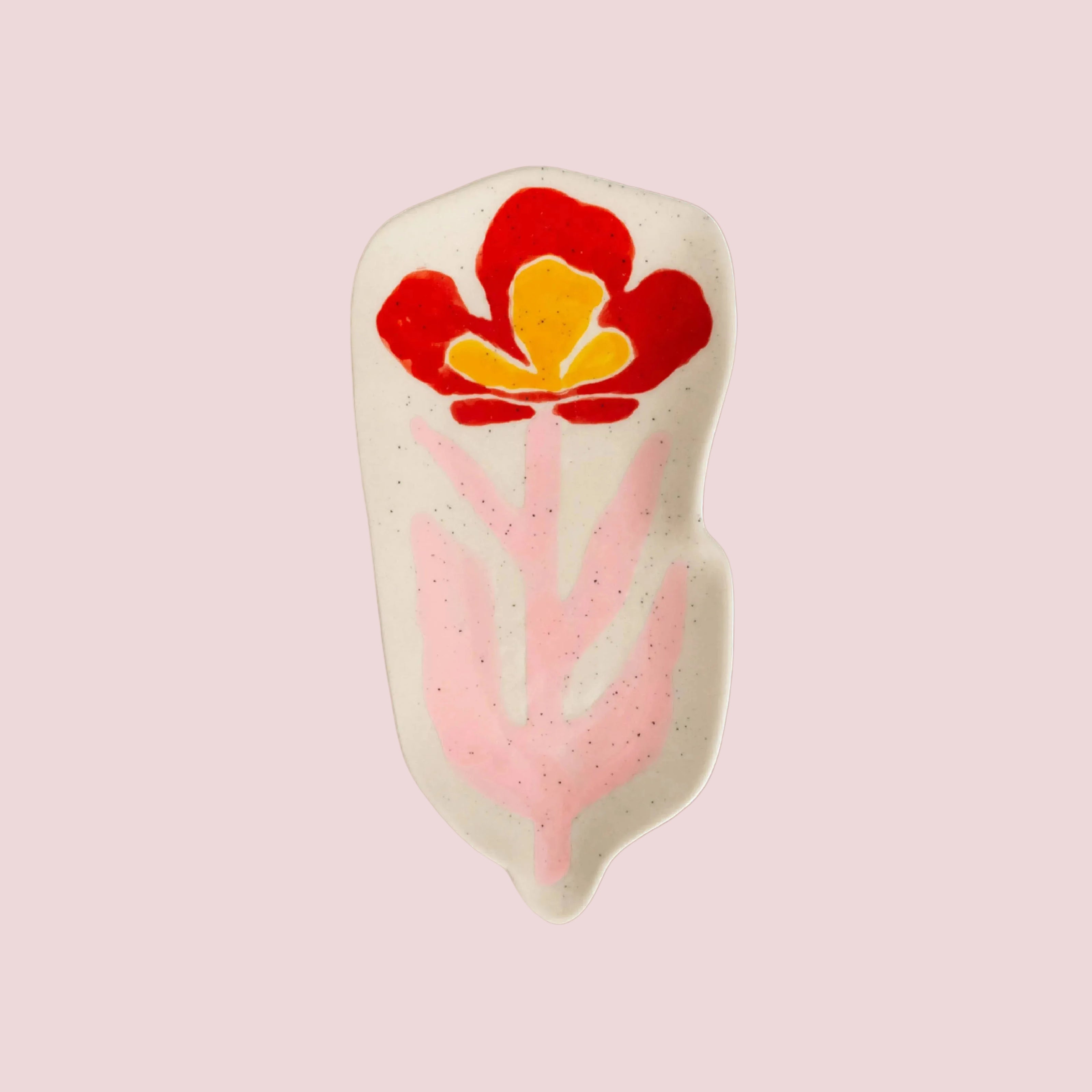 Decorative dish with a red and yellow floral design on a pink background