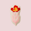 Decorative dish with a red and yellow floral design on a pink background
