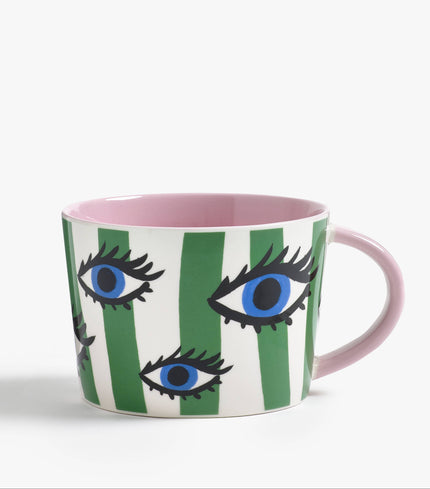 Mug with eye design and green stripes on a white background