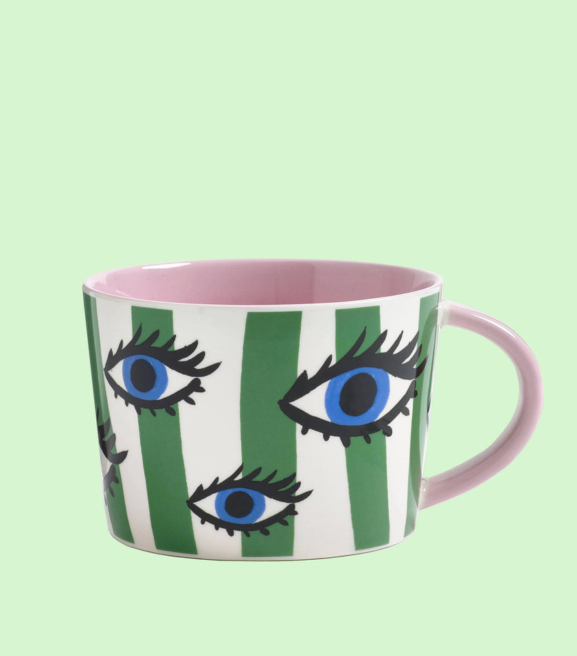 Mug with eye design and green stripes on a green background