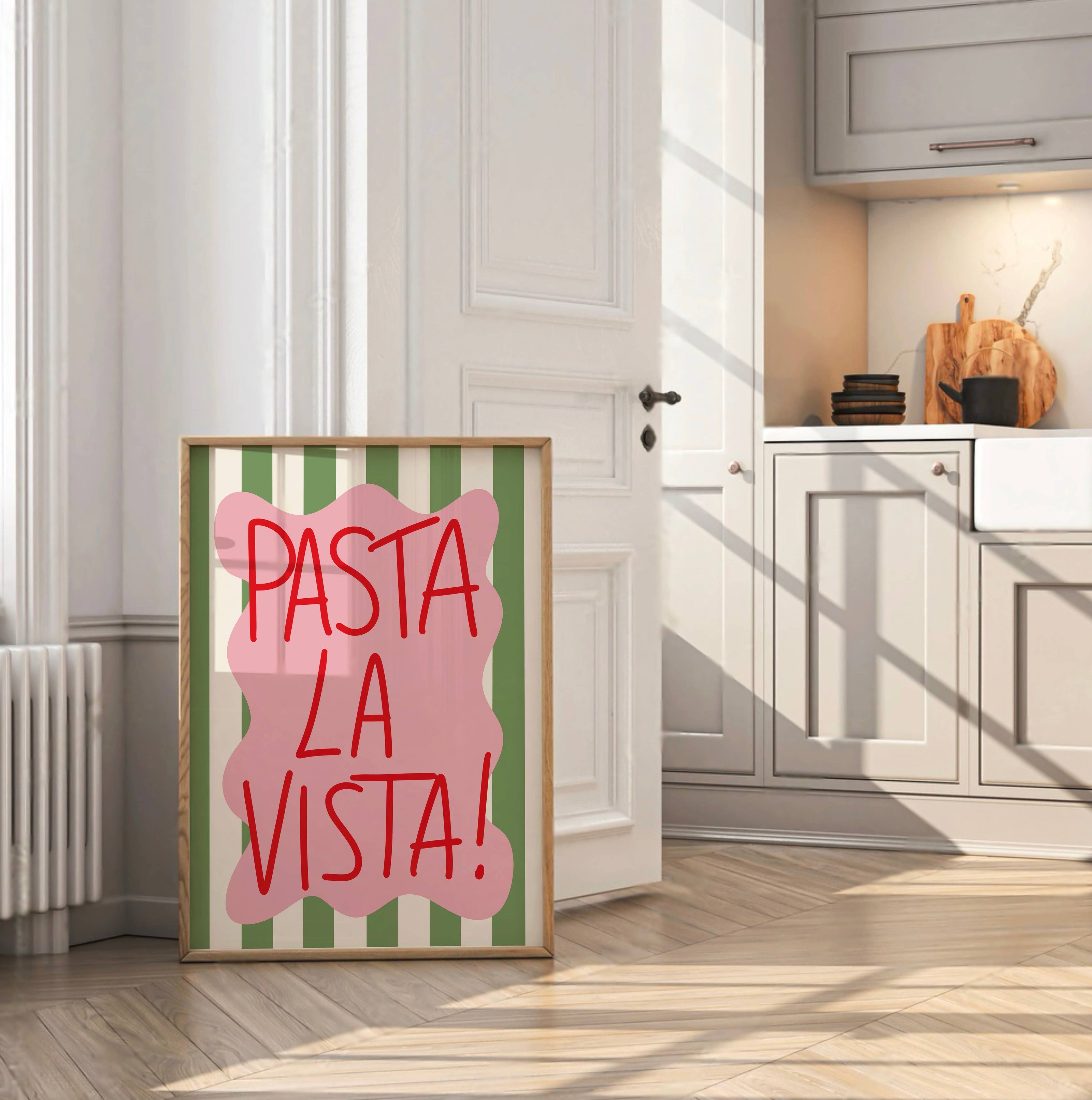 Framed artwork with 'Pasta La Vista!' text in a kitchen setting