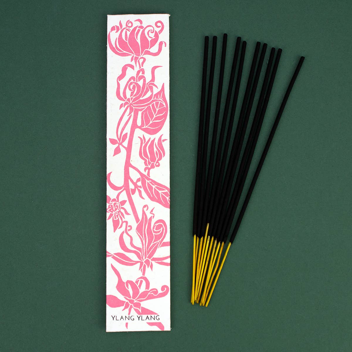 Ylang ylang incense sticks with a decorative Ylang Ylang packaging on a green background